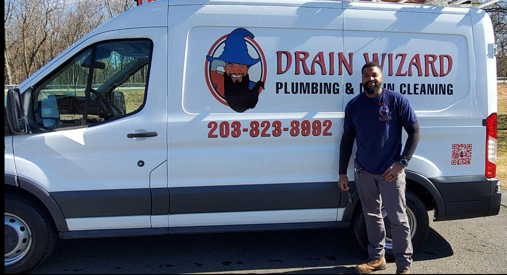 Robert Gathers, Founder and Connecticut P1 Master Plumber at Drain Wizard Plumbing, standing next to the branded service van