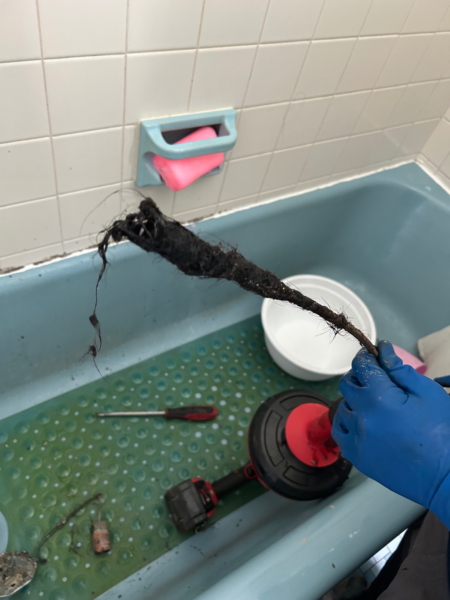 Drain Wizard technician pulling a hair and soap clog from a Connecticut tub drain